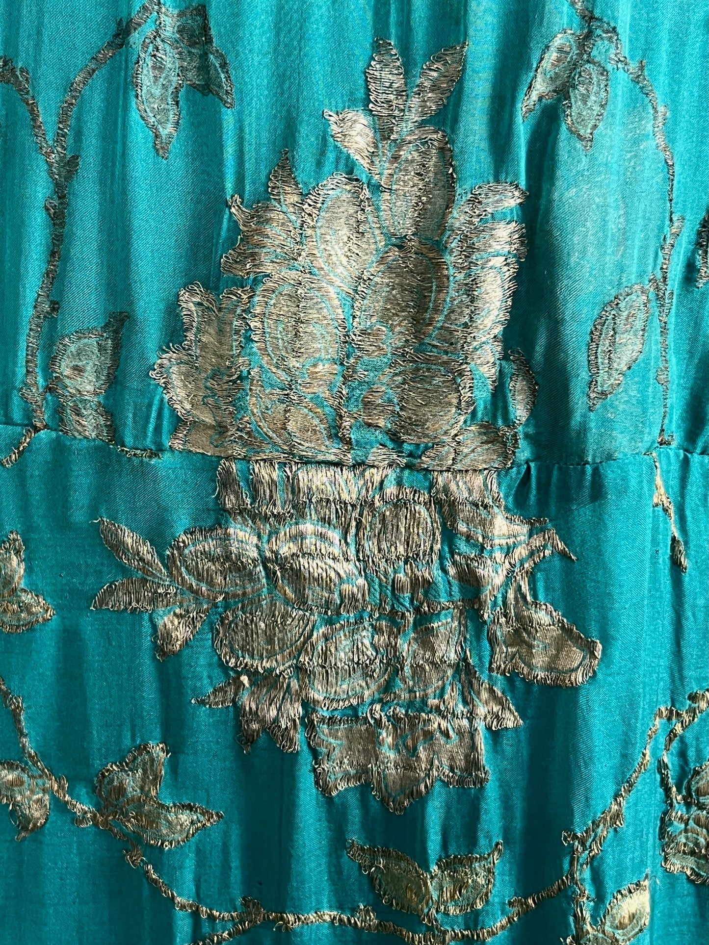Close-up of teal and metallic gold lamé fabric