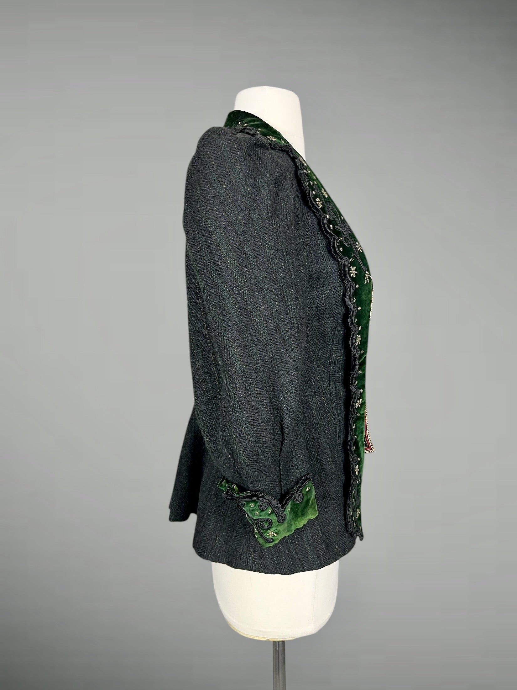 Dark gray green striped wool blazer with green velvet trim on a mannequin against a gray background