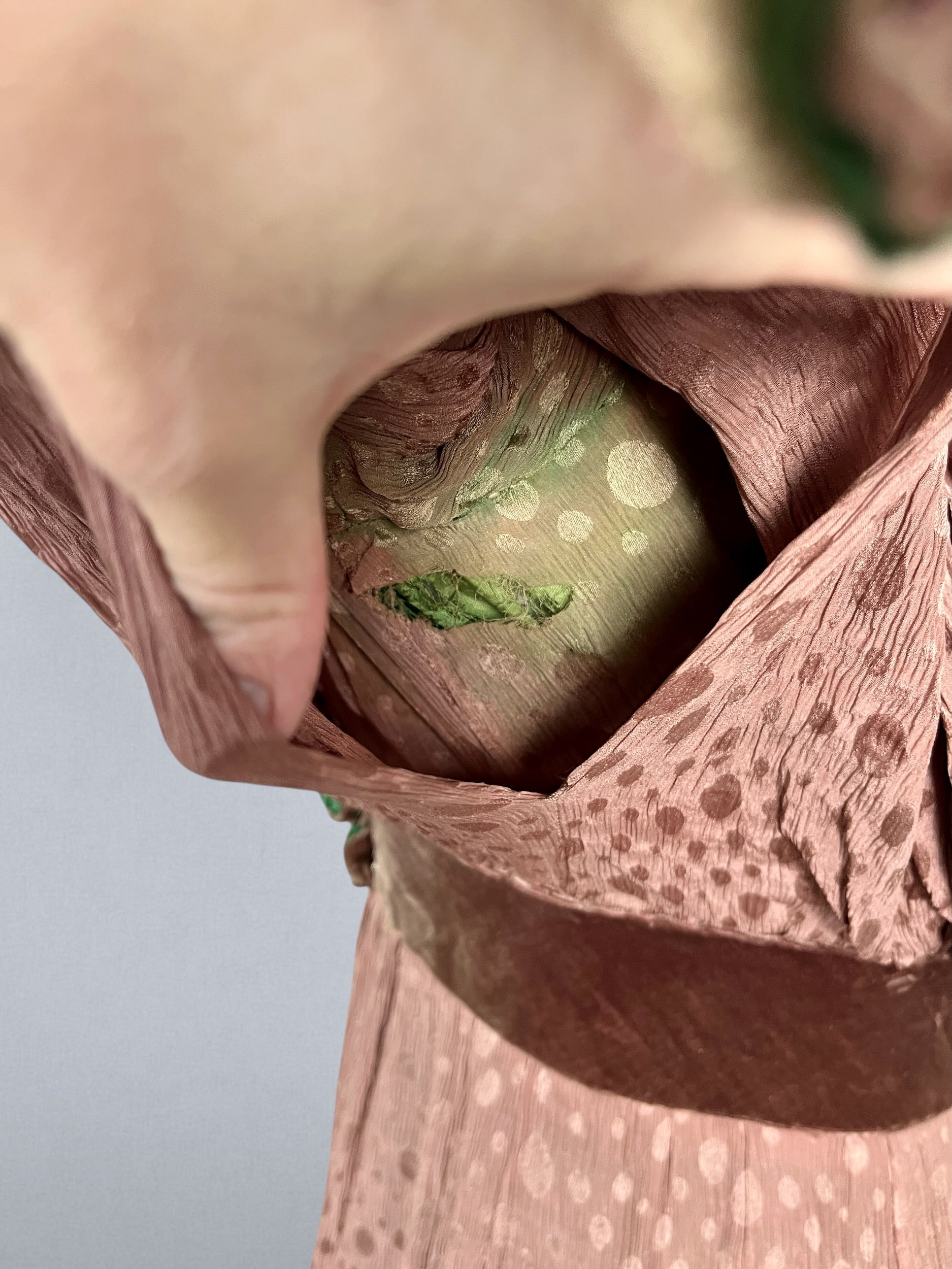 close-up of underarm showing tear to taupe silk and green discoloration